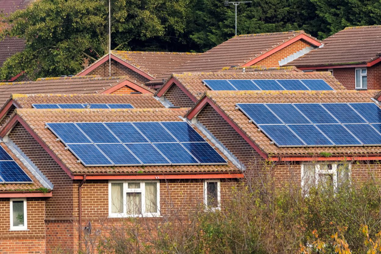 Multiple solar panels on roofs of houses